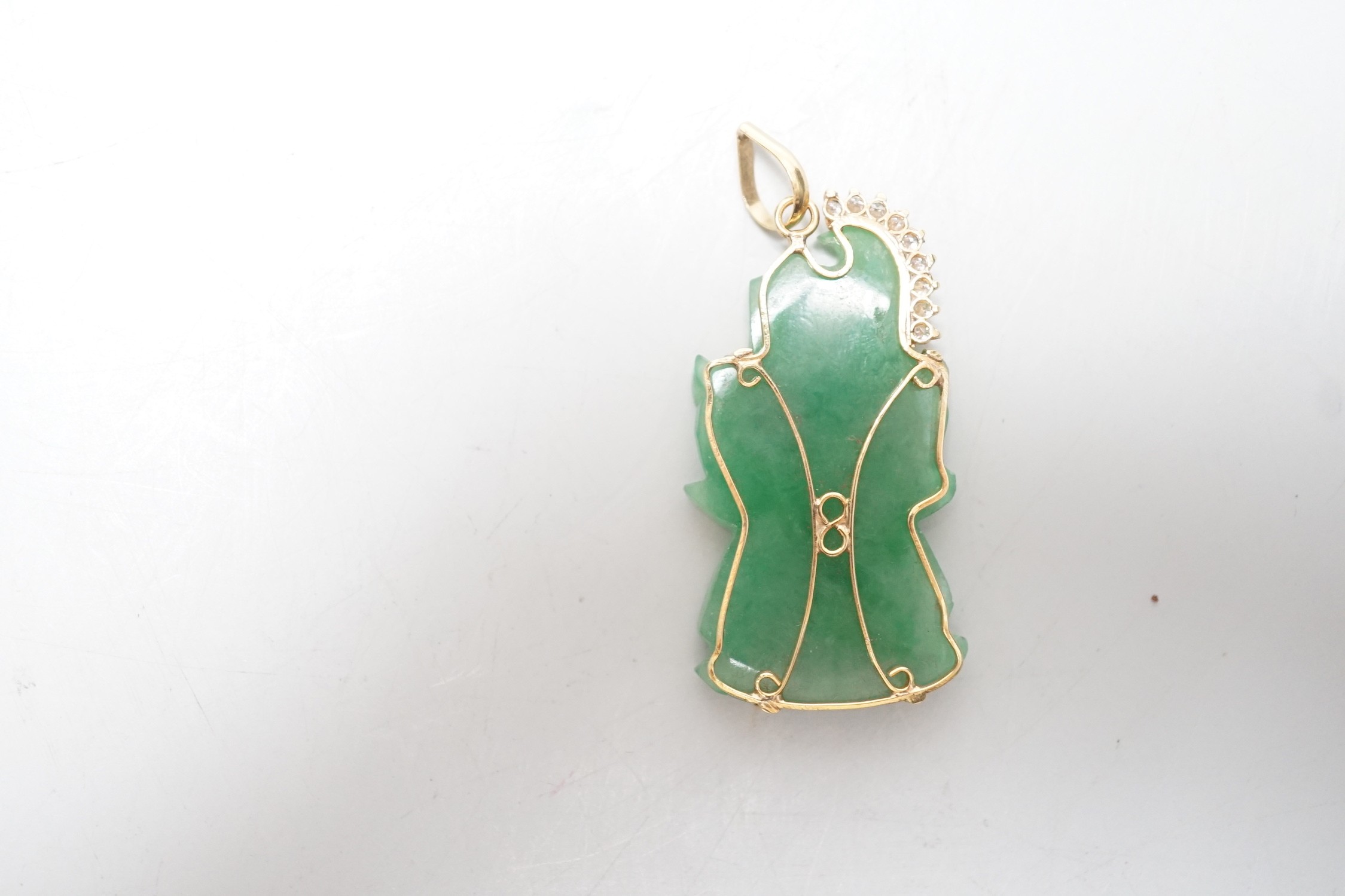 A modern 18k and diamond chip mounted jadeite pendant, carved as an immortal, 40mm, gross weight 9.1 grams.